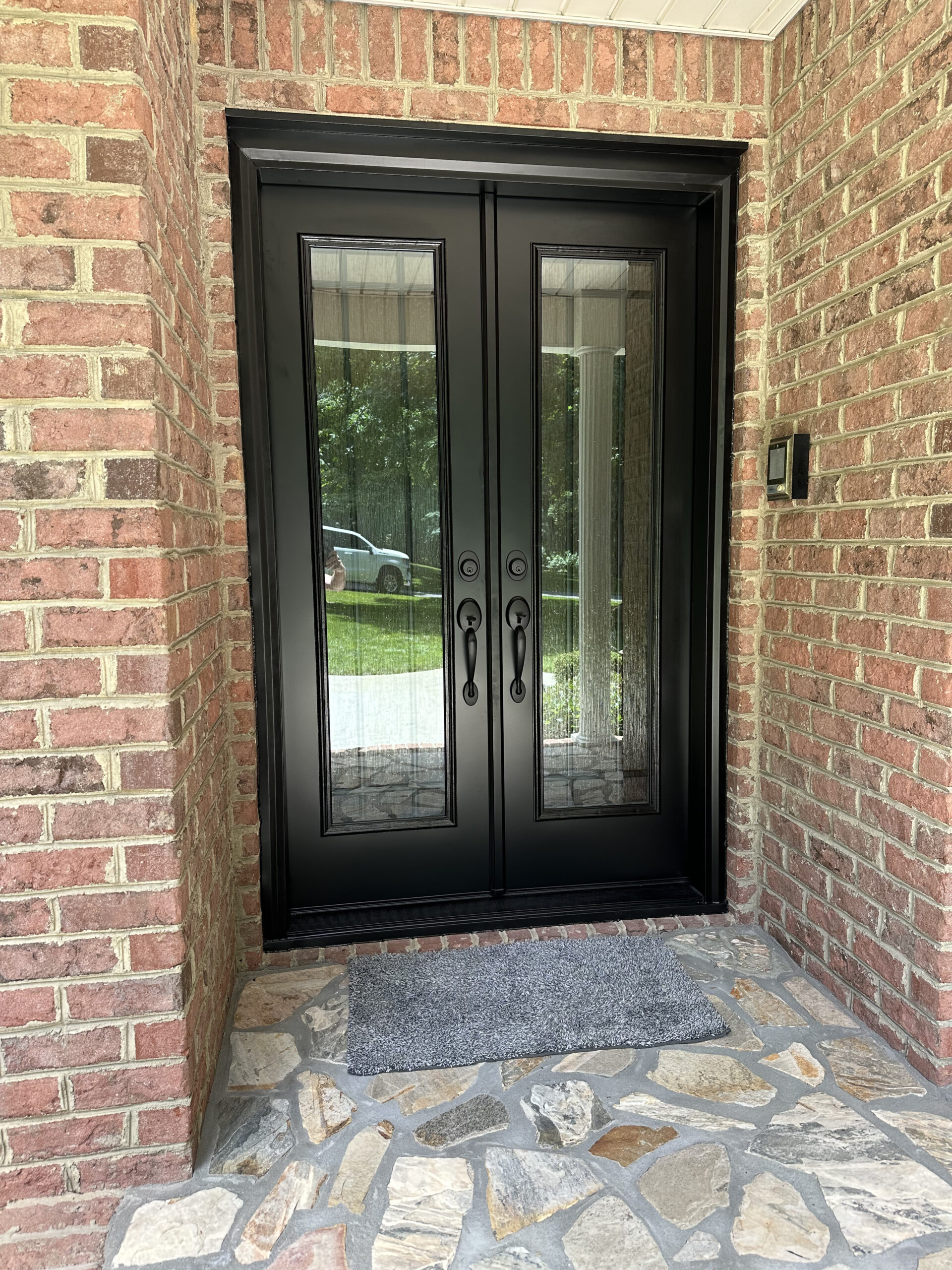 Technician performing entry door replacement at a Cornelius - NC home while checking hinges and threshold
