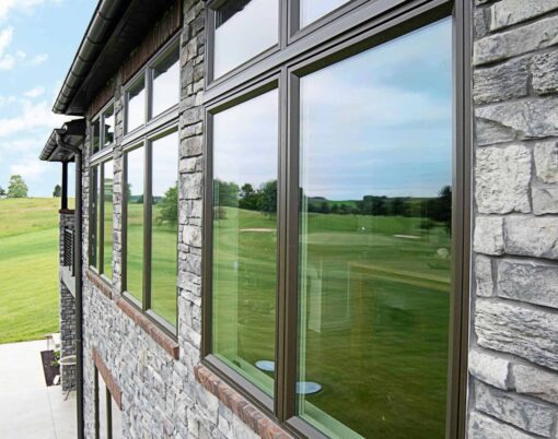 ProVia Aeris wood-clad casement windows installed on stone home.